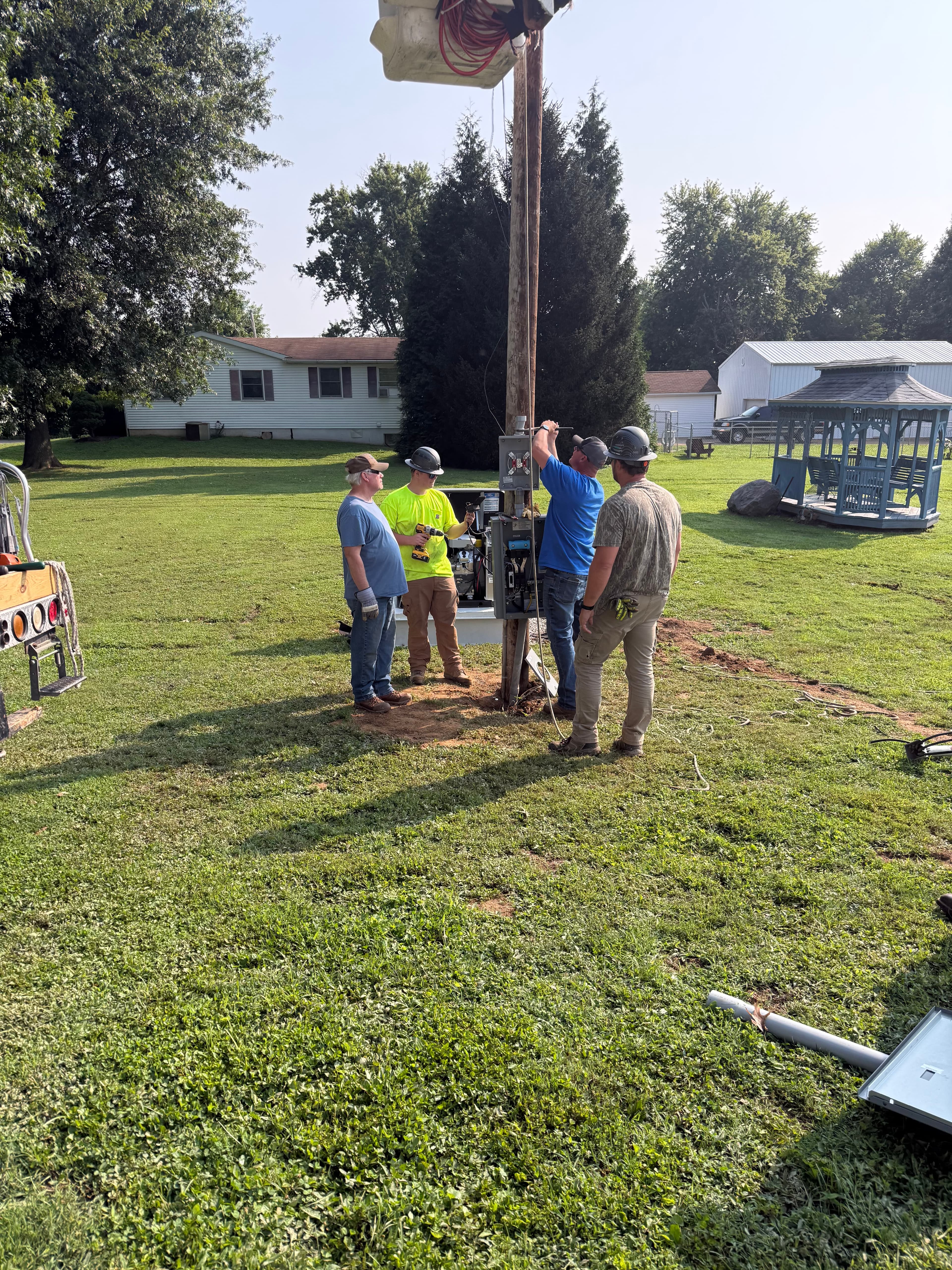Genset Tech crew working on-site around a utility pole and service equipment