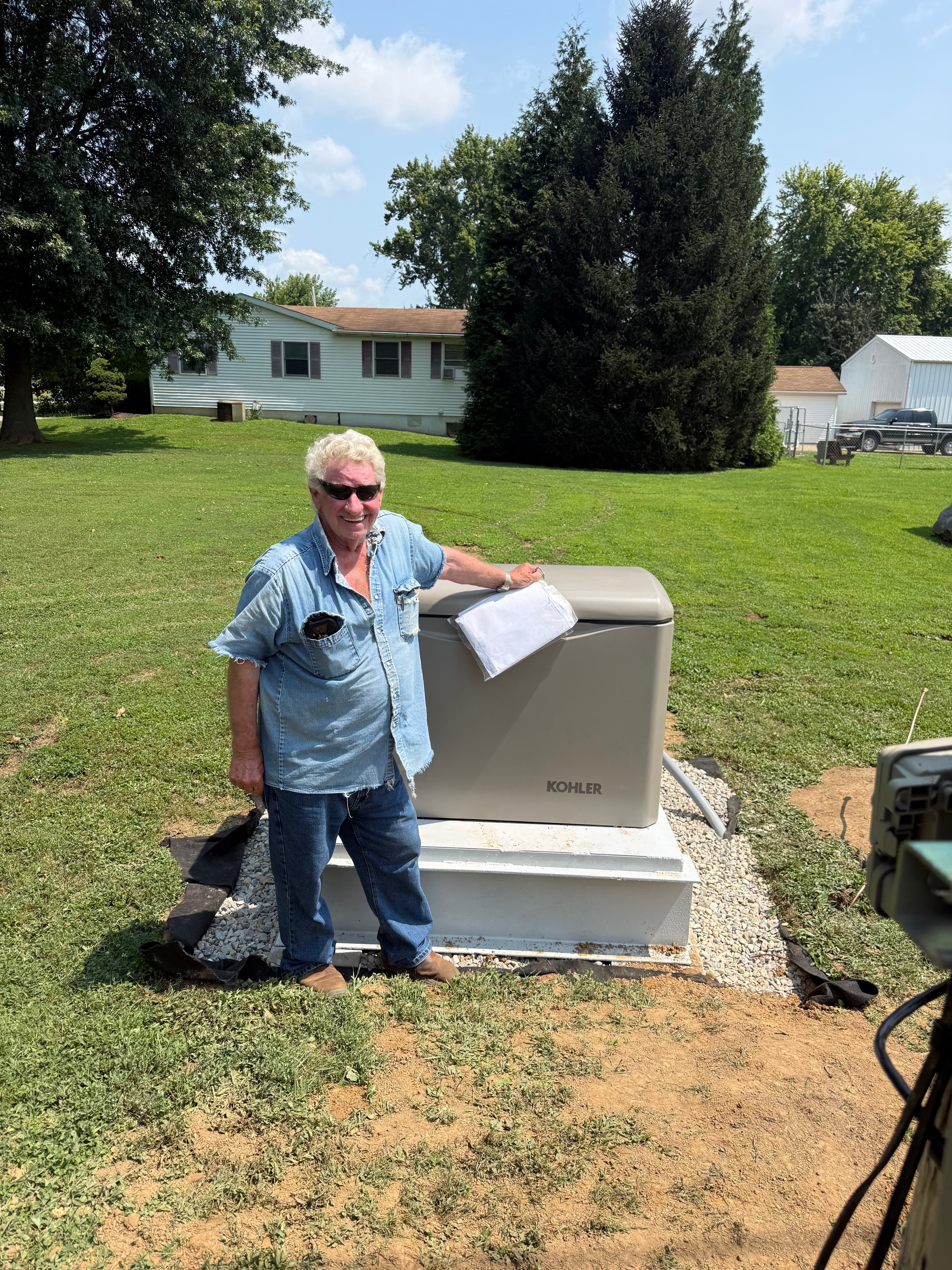 Homeowner standing beside a newly installed residential standby generator