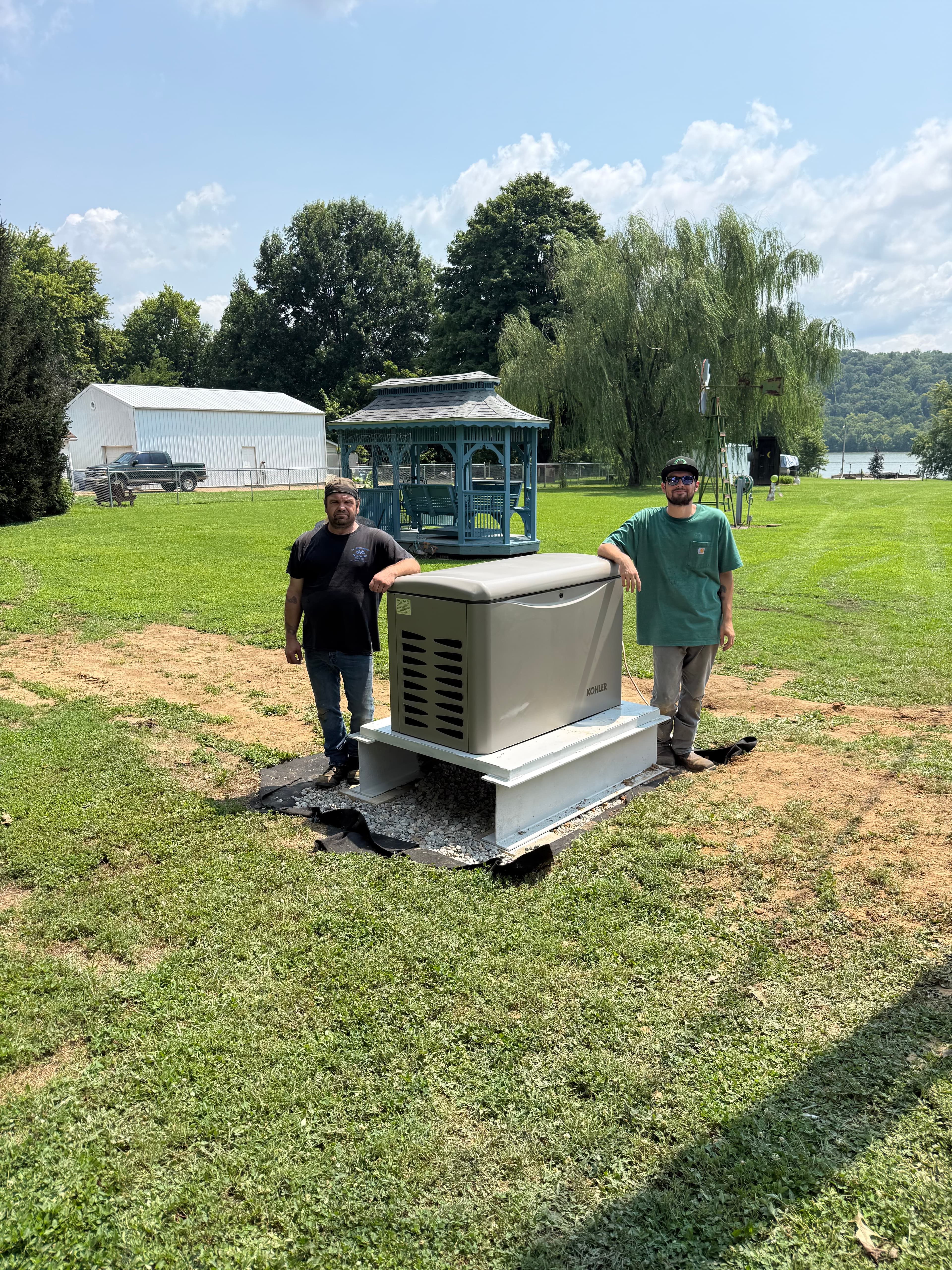 Two Genset Tech team members standing beside a newly installed residential standby generator